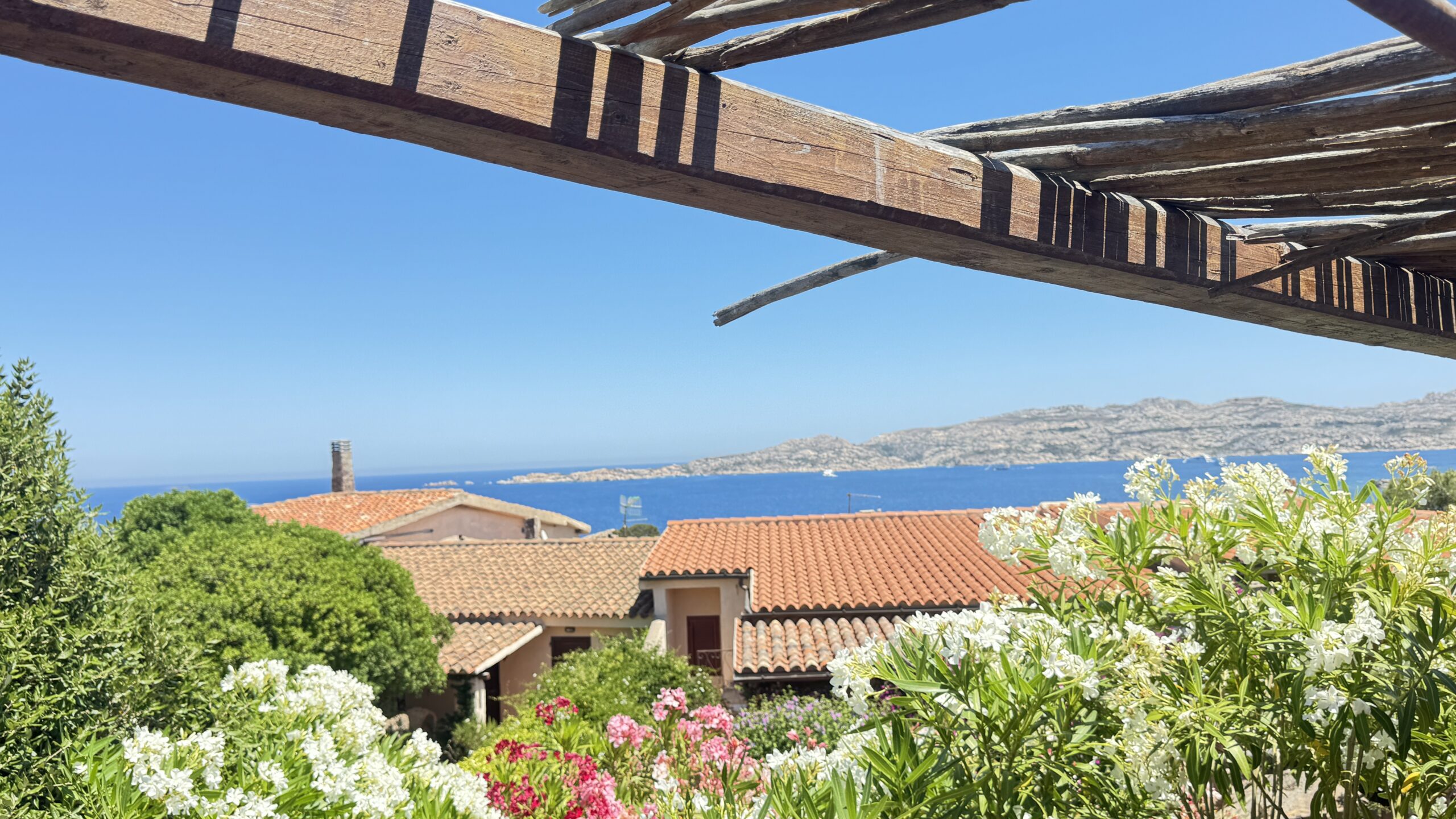 View over terracotta rooftops toward the sea near Punta Tegge