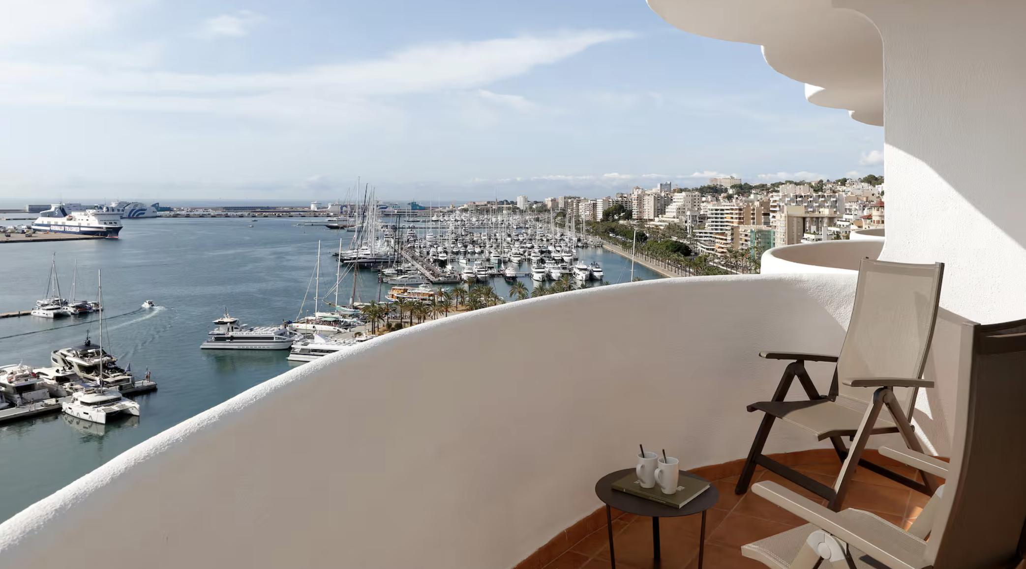 Marina with boats, palm trees, and Hotel Palma Bellver in Palma de Mallorca