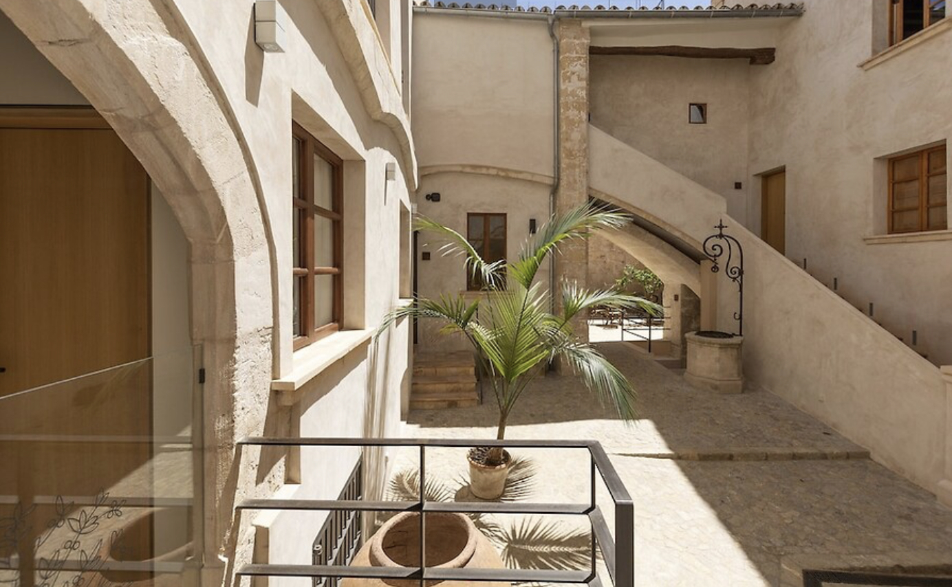 Gothic stone courtyard with palm tree at Hotel Can Cirera, Palma old town